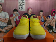 Front view of yellow Nike sneakers with red tongue labels, yellow laces, and white outsoles.