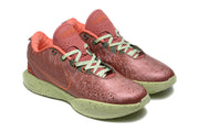 Front three-quarter view showing the patterned orange-red uppers, green laces, perforations, and green soles.