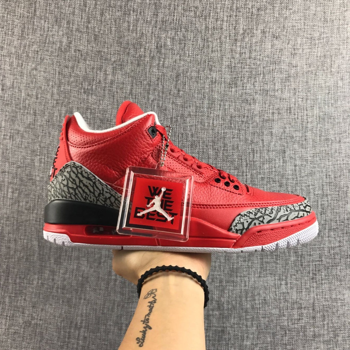 Side view of a red Air Jordan 3 sneaker with elephant-print panels and a visible heel unit.