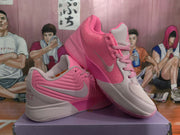 Angled side view of pink and light pink Jordan sneakers showing contrasting panels, laces, side branding, and textured outsoles.