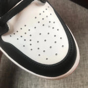 Close-up of the perforated white toe box bordered by black overlays.