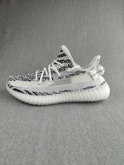 Side profile highlighting the knit upper, white midfoot panel, heel pull tab, and ribbed sole.