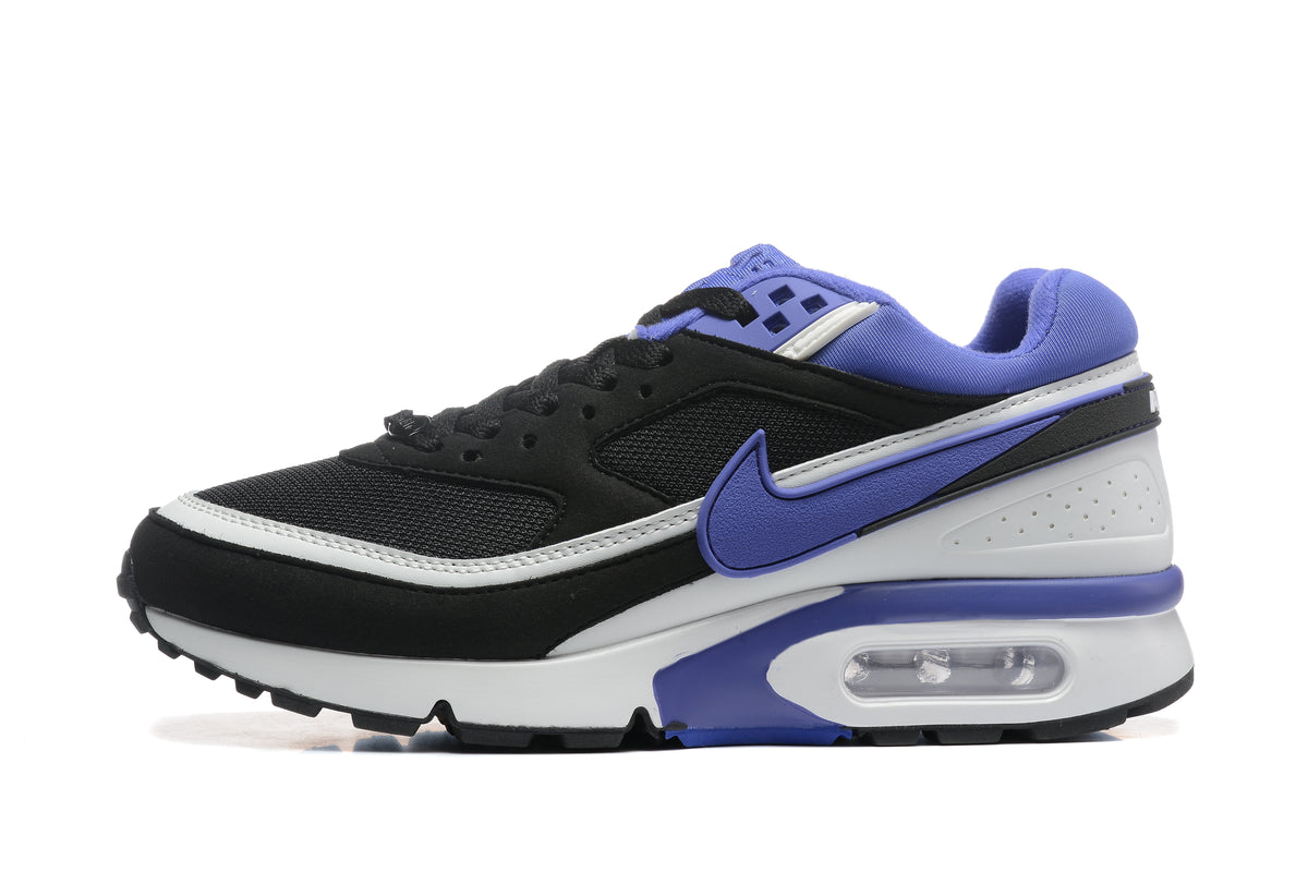 Side view of a black Nike sneaker with purple accents, a white midsole, and a visible heel air unit.