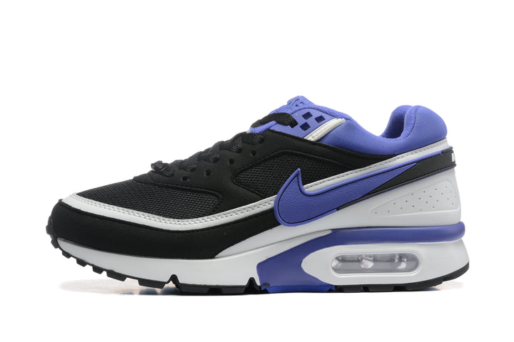 Side view of a black Nike sneaker with purple accents, a white midsole, and a visible heel air unit.