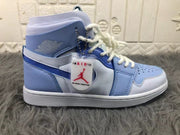 Side profile of the sneaker with visible ankle branding, attached hangtag, perforated toe panel, and layered upper.