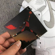 Close-up of the ankle wings emblem, grey Swoosh, and attached graphic tag.