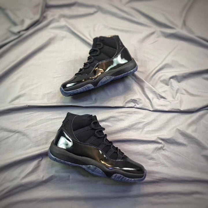 Pair of black high-top sneakers shown from an angled side view on a light fabric backdrop.