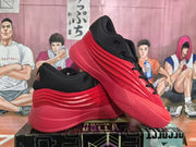 Angled view of two red and black Adidas basketball sneakers showing the upper, side panels and textured outsole.