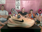 Side profile of a pink Nike basketball sneaker with black Swoosh branding and tonal laces.