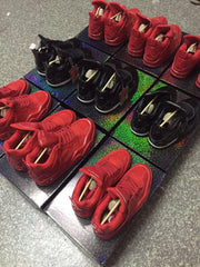 Rear and side views of red and black high-top sneakers on patterned boxes.