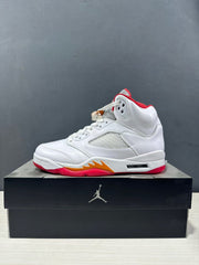 Side profile of a white Jordan high-top sneaker with a red collar, orange midsole detail and visible heel cushioning window.