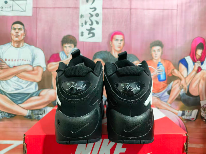 Rear view of black Nike sneakers with white accents and Flight branding on the heel.