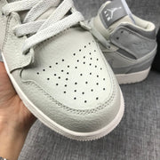 Close-up of the perforated toe box and textured upper on one sneaker.