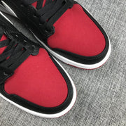 Close-up of the pair's red toe panels, black edging, black laces, and white midsole trim.