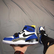 Side view of a blue, white, and black high-top sneaker with an elephant-print panel and adjustable strap.