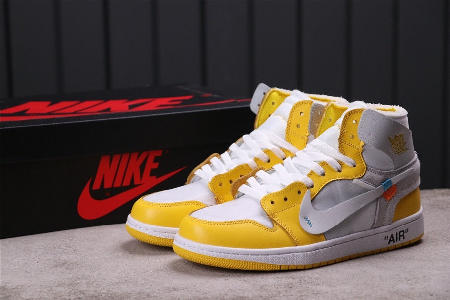 Pair of white, yellow, and grey high-top Jordan sneakers shown with a black branded shoe box.