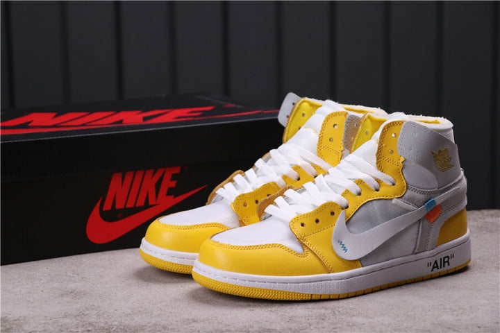 Pair of white, yellow, and grey high-top Jordan sneakers shown with a black branded shoe box.