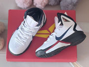 Top and side views of the lace-up basketball shoes on a red box