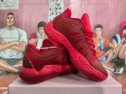 Red basketball-style sneakers shown from the side and sole, with sculpted outsole details.