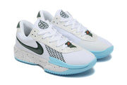 Angled view of the pair showing white uppers, green details, light blue soles, and speckled midsoles.