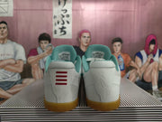 Rear view showing the white heels, teal collars, and gum-colored outsoles of Nike Kobe shoes
