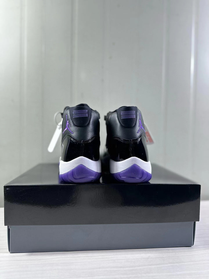 Rear view of black and purple high-top sneakers displayed on a black shoebox.