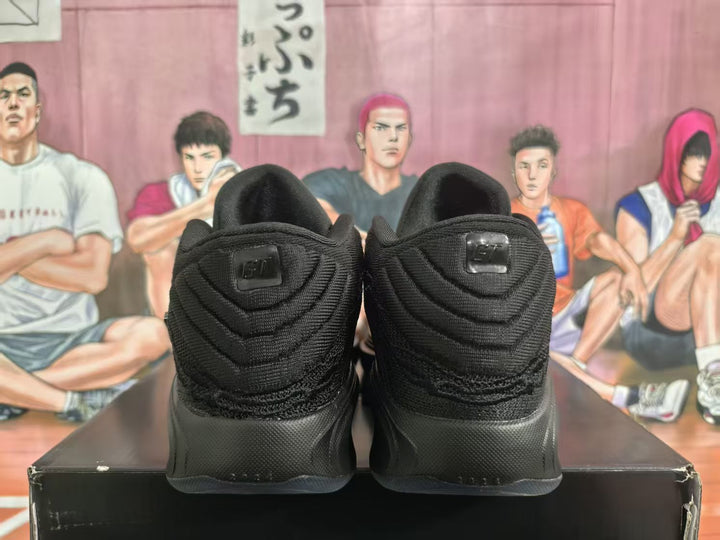 Rear view of the black Nike basketball shoes showing textured heels and heel details.