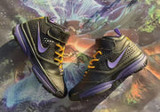 Pair of black and purple sneakers shown diagonally with their ankle straps and textured side panels visible.