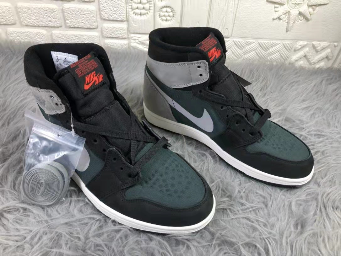Pair of black, dark green and grey Jordan high-top sneakers shown from an angled front view with an additional lace bundle.