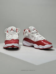 Front three-quarter view of the white and red high-top Jordan sneakers with glossy red toe panels.