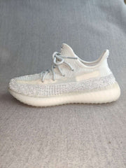 Side profile highlighting the white upper, silver reflective-looking stripe, and translucent sole.