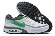 Side and outsole views of white sneakers with green accents and a visible midsole air unit.