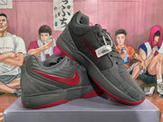 Angled view of grey and red Nike basketball sneakers showing the side branding, padded collars, laces and red treaded soles.