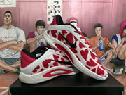 Angled view of the pair showing the patterned white and red uppers, black Swooshes, and white soles.