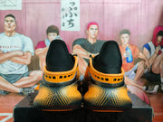 Rear view of the orange and black sneakers showing padded black heel sections and the patterned heel outsole.
