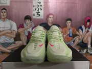 Front view of the paired light green basketball sneakers showing the laces, pink Swoosh details, and translucent toe sections.