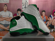 Angled view of the pair highlighting the white perforated side panels, green midsoles, black outsole sections, and heel details.
