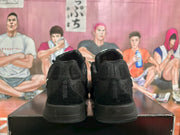 Rear view of the black Nike sneaker pair, showing the padded heel panels and black midsoles.