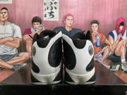 Rear view of black and white high-top sneakers showing contrasting heel panels and circular heel details.
