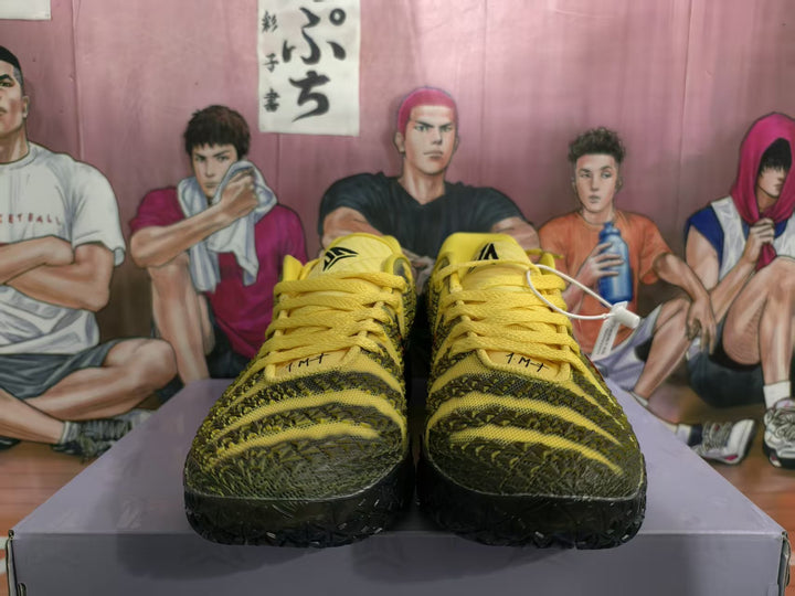 Front view of yellow and black Nike basketball-style sneakers displayed on a box.