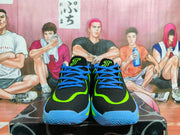 Front view of black Jordan basketball shoes with blue laces and volt-green trim.