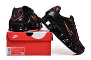 Black Nike Shox TL sneakers with orange Swooshes and pink trim displayed with a shoe box