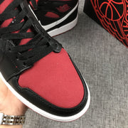 Close-up of the red textile-looking toe panel, black laces, and black-and-white trim.