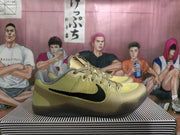 Side view of gold-toned Nike basketball shoes showing the black Swoosh, textured upper and dark translucent outsole.