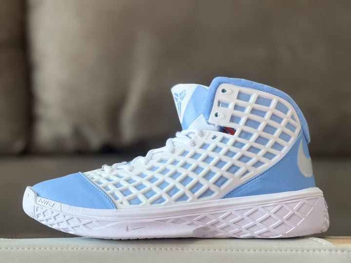 Side view of a light blue and white high-top Nike Kobe 3 basketball shoe with a patterned white side panel.
