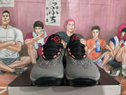 Front view of a pair of black and gray Nike sneakers showing black laces, textured uppers, and red tongue details.