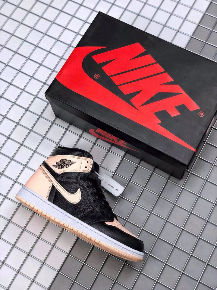 Black and light pink high-top sneaker beside a Jordan-branded shoe box.