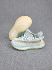 Side view of the sneaker pair showing the tan side stripe, laces, and lightly tinted sole.