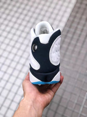 Rear view of the sneaker showing the black heel panel, white collar, and blue outsole edge.