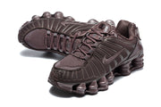Top and angled view of dark brown Nike Shox TL sneakers showing laces and mesh panels.
